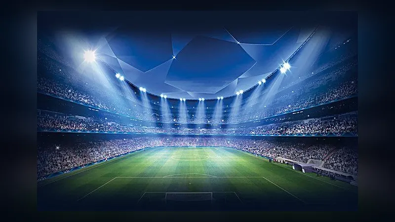 A packed football stadium at night under bright floodlights